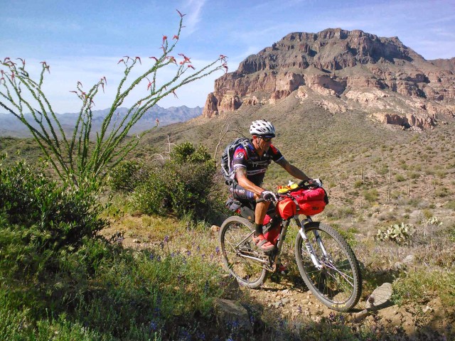 Larry rounds the corner with an impressive view of Picketpost Mtn cheering him on.